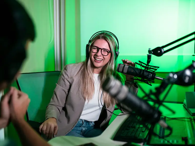 Two podcasters recording an episode together in a studio